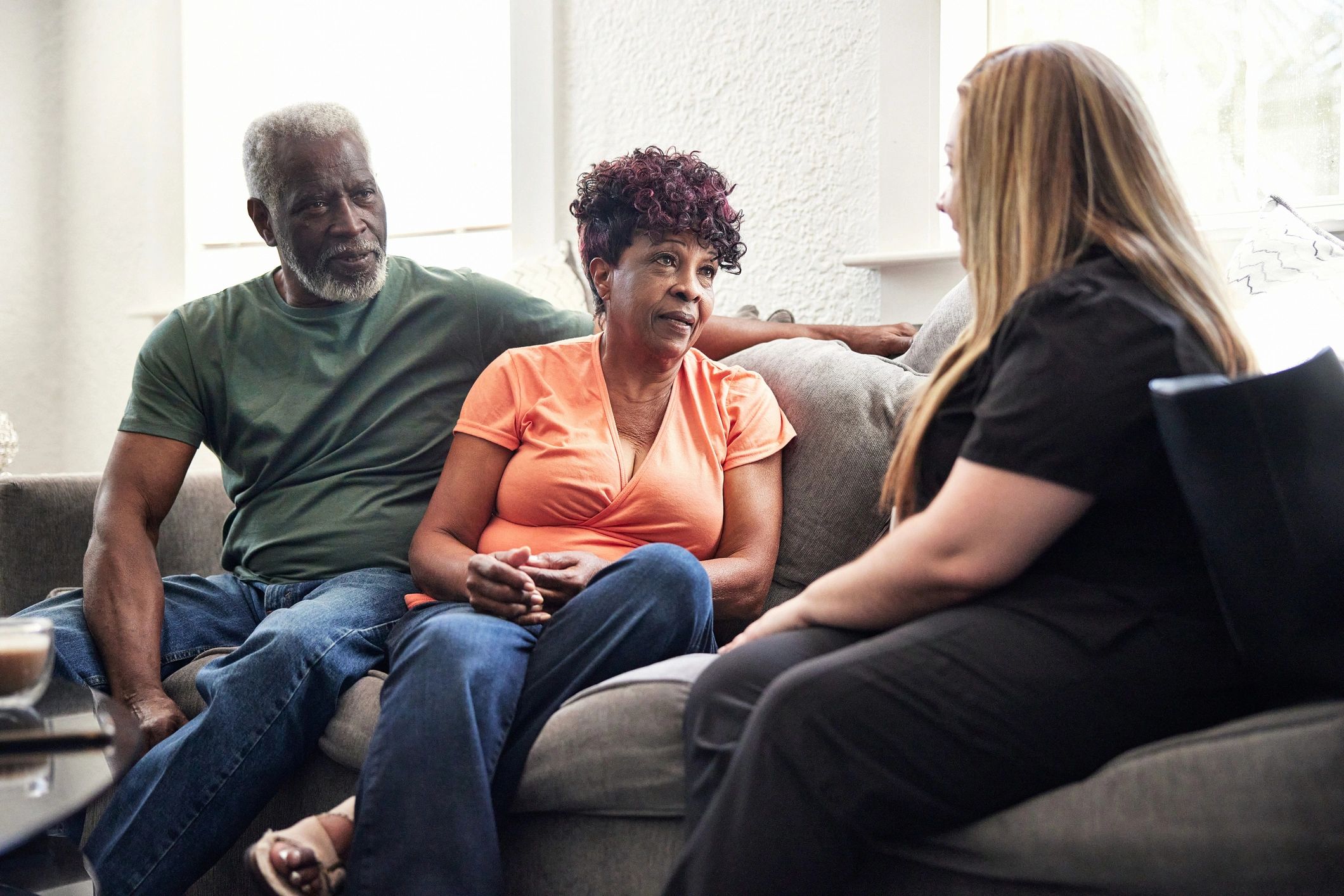 Caregiver talking with adult family members in a calm home setting
